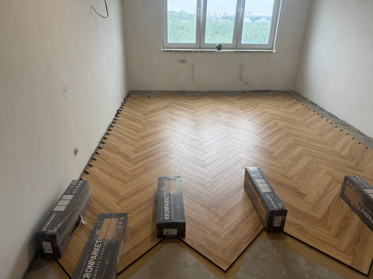 Укладка ламината ёлочкой в комнате во время ремонта квартиры